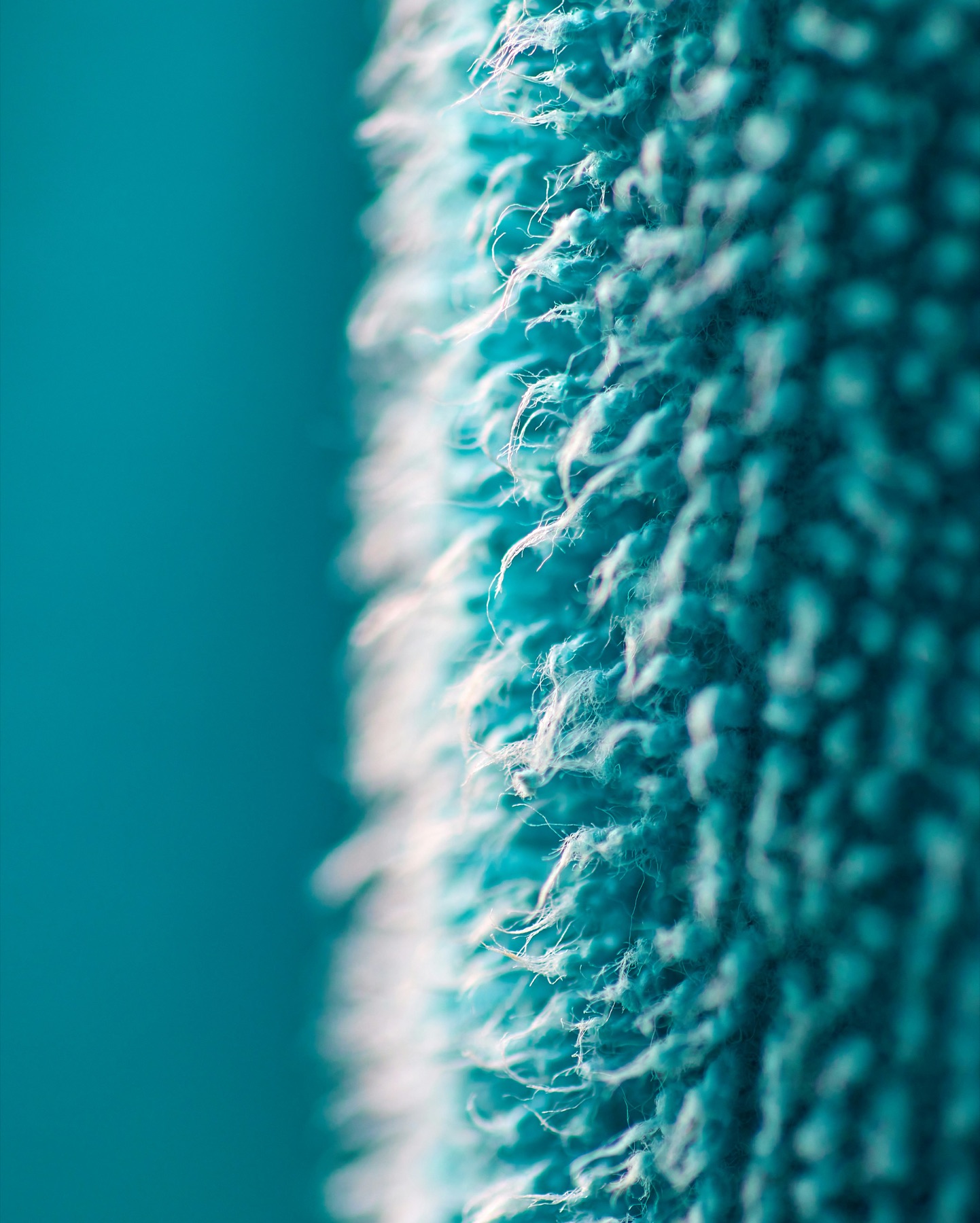 A turquoise microfiber cloth, close enough to count the fibers